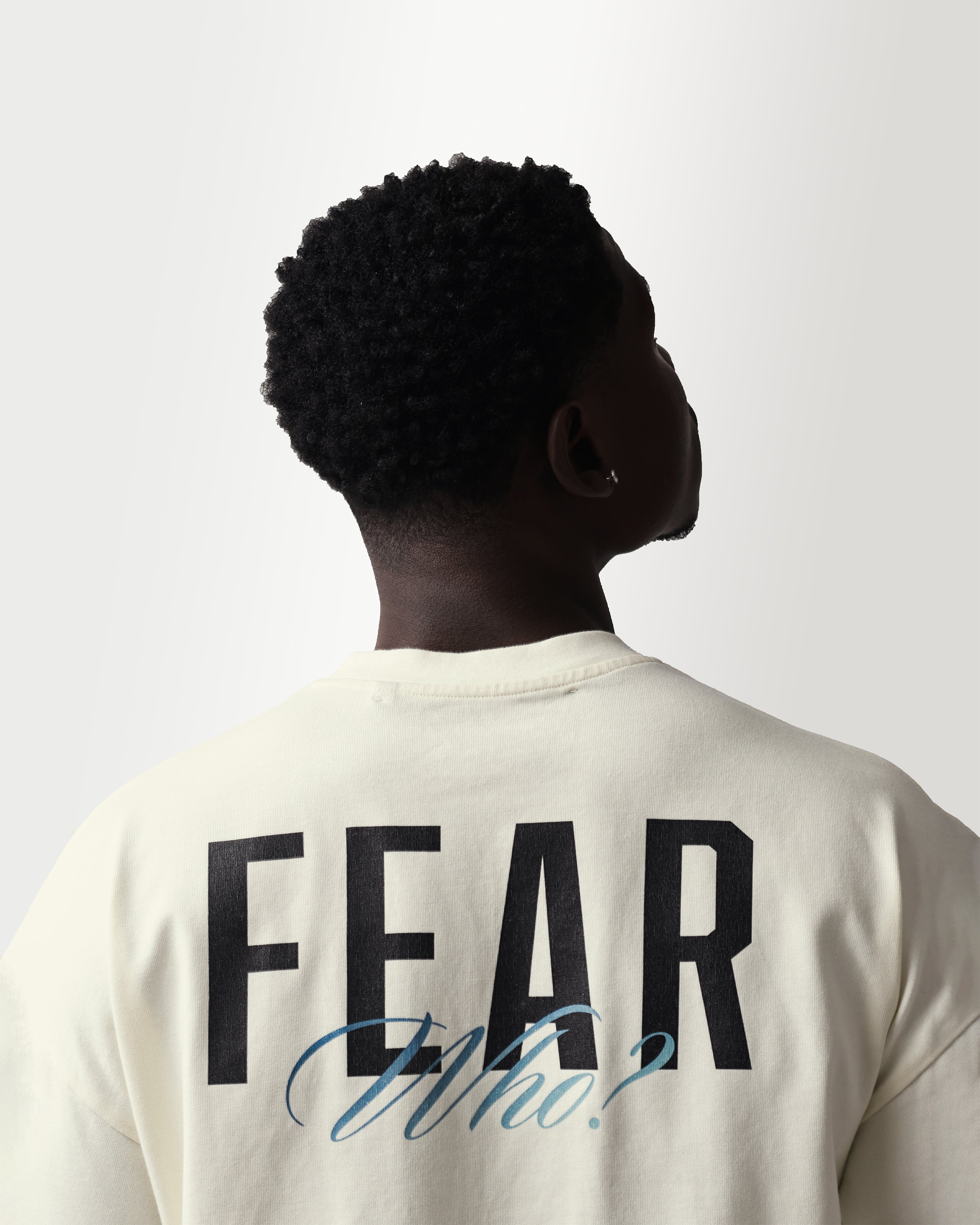Person wearing a shirt with 'FEAR Who?' text on the back against a white background